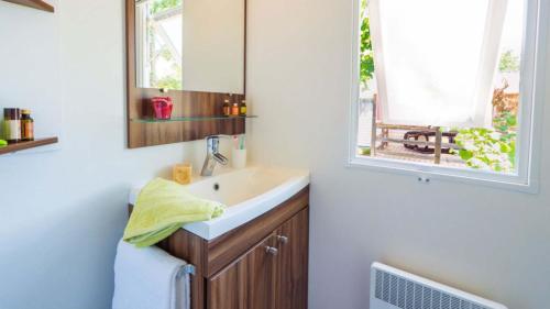 a bathroom with a sink and a mirror and a window at Eurocamp Mobile Homes at Campsite Valkanela in Funtana