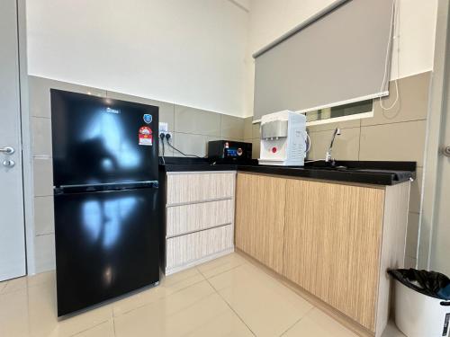 a kitchen with a black refrigerator in a room at 马六甲 Melaka Amber cove residence Jonker Street in Melaka