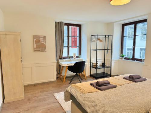 a bedroom with two beds and a desk in it at A&Y LakeHouse Golden Swan in Luzern