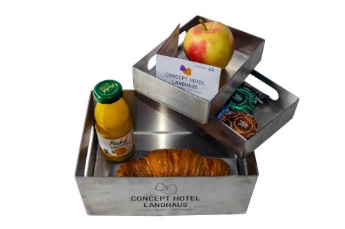 a box of food with an apple and a loaf of bread at Concept Hotel Landhaus in Burgdorf