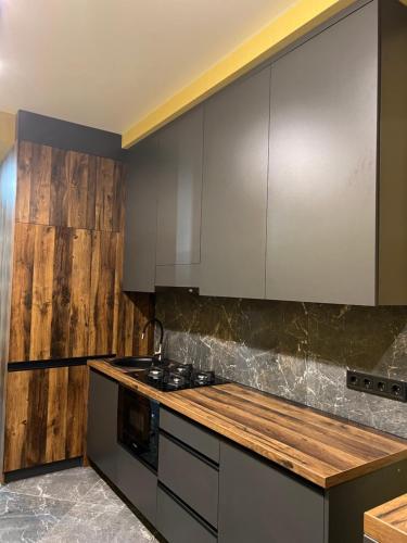 a kitchen with stainless steel appliances and wooden walls at Apartments Lux in city center Lviv in Lviv