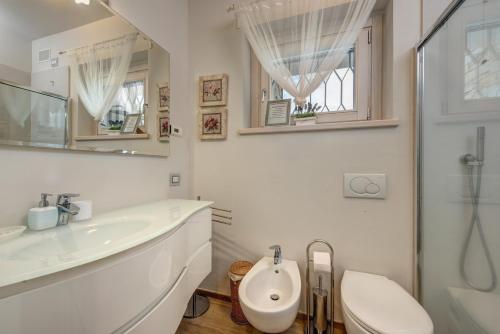 a white bathroom with a sink and a toilet at Villa La Corte with amazing pool and garden in Colico