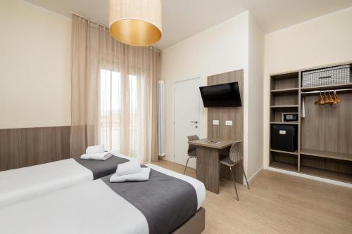 a hotel room with two beds and a desk at Hotel Maggiore in Bologna