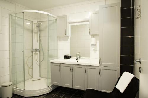 een witte badkamer met een douche en een wastafel bij Lyngen Experience Apartments in Nord-Lenangen