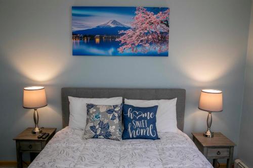 a bedroom with a bed with two lamps and a painting on the wall at Tiki on the Lake in Hammondsport