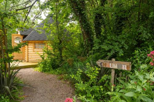 un panneau devant une cabane en rondins dans l'établissement Gite Petite Chaumière Kota finland, à Plurien