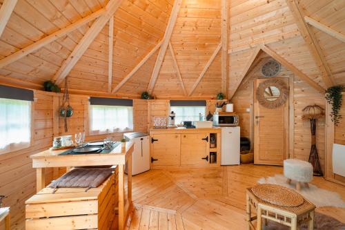 una grande cucina con pareti in legno e soffitto in legno di Gite Petite Chaumière Kota finland a Plurien