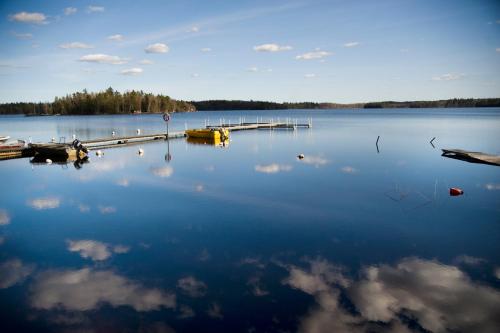 a large body of water with a dock and clouds at Toftastrand Hotell in Växjö