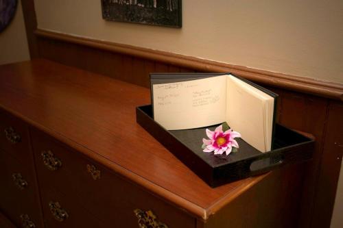 a book and a flower in a box on a dresser at The Champagne Suite 2 in Hammondsport