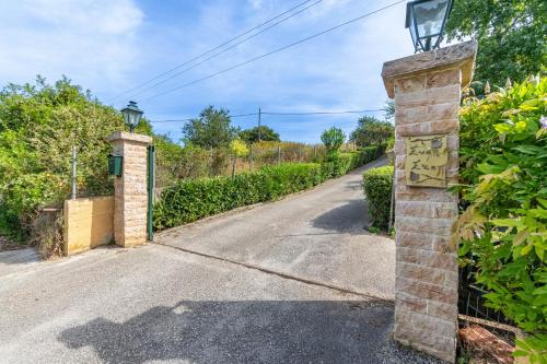 an entrance to a driveway with a brick pillar at Even Ezer with private pool in Pouládes