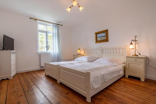 - une chambre avec un grand lit blanc et une fenêtre dans l'établissement Ferienwohnung Königssee, à Sassnitz