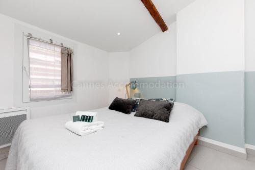 une chambre avec un lit blanc avec deux oreillers dans l'établissement Bronze, à Cannes