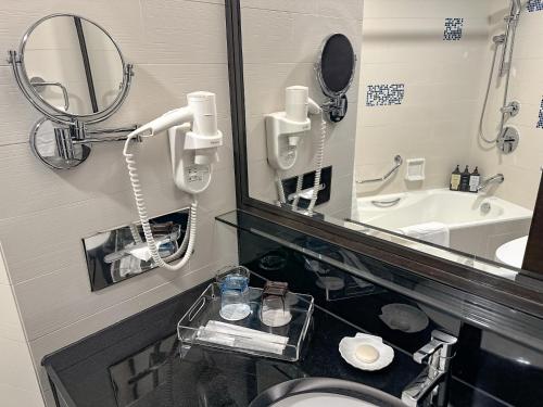 a bathroom with a mirror and a toilet and a sink at South Pacific Hotel in Hong Kong