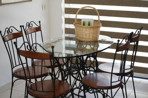 una mesa de cristal con sillas y una cesta en la parte superior en Searenity Seafront house - 50m from the beach, en Lárnaca