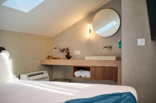 een slaapkamer met een bed, een wastafel en een spiegel bij Central Heritage Hotel in Split