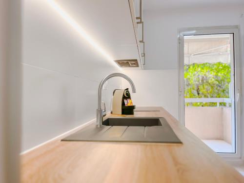 une cuisine avec un évier et une fenêtre dans l'établissement Le Cannes Mélodie - Terrasse, à Cannes