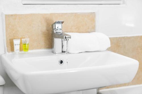 a bathroom sink with a faucet with towels on it at Stylish Apartment - Fast WiFi - Wolverhampton 9aPC in Wolverhampton