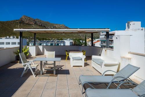 a patio with tables and chairs on a roof at Can Fiol ii in Port de Pollensa