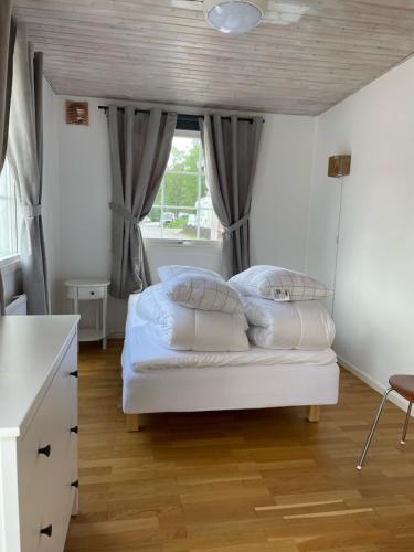 ストックホルムにあるStockholm Ängby Campingの白いシーツと枕が備わったベッドのある寝室