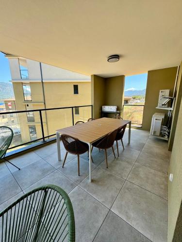 une salle à manger avec une table et des chaises sur un balcon dans l'établissement Appartement confort vue mer, à Propriano