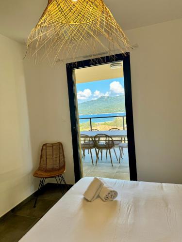 une chambre avec un lit et une vue sur l'océan dans l'établissement Appartement confort vue mer, à Propriano