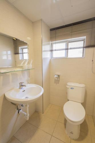 a bathroom with a toilet and a sink at Tzu Chi Hotel in Pingtung City