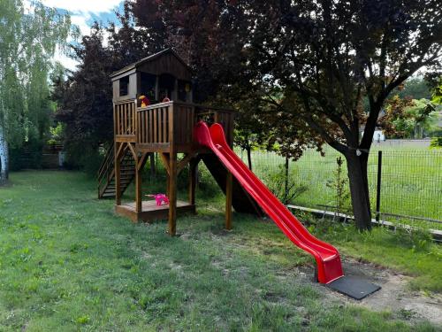 a playground with a slide and a play house at Evie's Tree House in Dragomirna