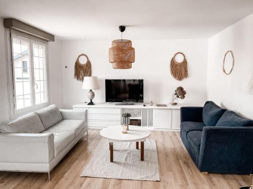 a living room with a couch and a tv at Grande maison 17 personnes 10 kms des plages in Arzal