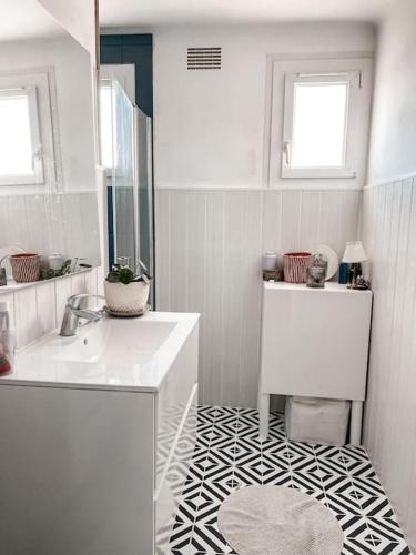 une salle de bain blanche avec un lavabo et un miroir dans l'établissement Grande maison 17 personnes 10 kms des plages, à Arzal