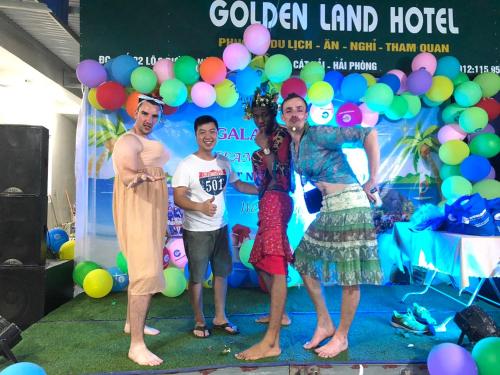a group of people standing in front of a backdrop with balloons at GOLDEN LAND HOTEL in Cat Ba