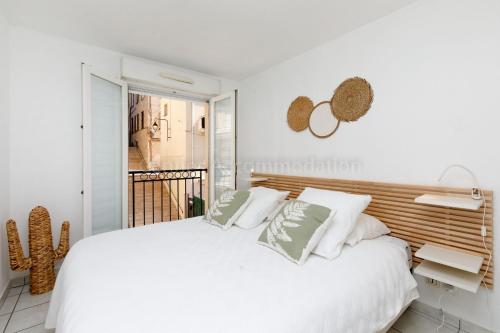 une chambre blanche avec un grand lit blanc avec des oreillers dans l'établissement Palazzio RE, à Cannes