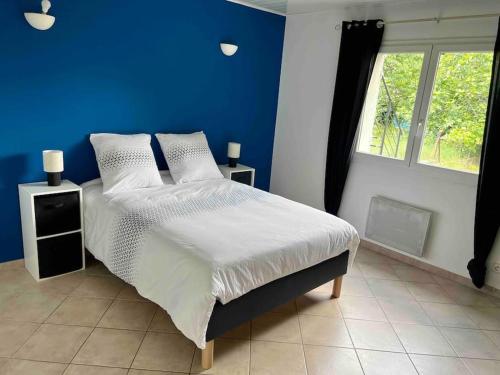 une chambre bleue avec un lit et une fenêtre dans l'établissement Location entre mer, montagne et rivières, à Casanova