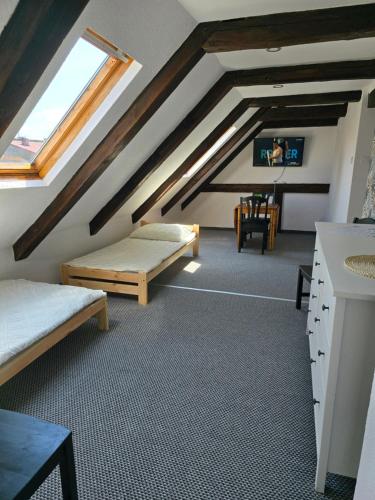 a attic room with two beds and a tv at Zakątek Bursztynowy in Łeba