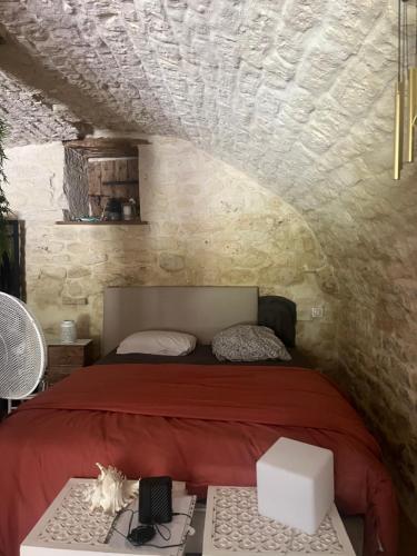 a bedroom with a bed in a stone wall at Voute des anges type loft sans cloison in Castelnau-Montratier