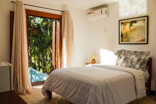 una camera da letto con un letto e una grande finestra di Casa Barco Ferradura - Pousada a Búzios