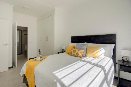 a bedroom with a large bed with yellow pillows at Cozy retreat in Fourways in Johannesburg