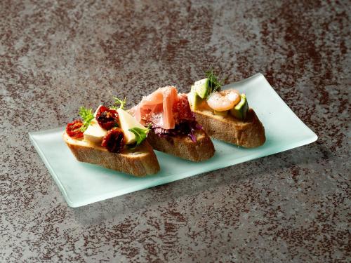 two pieces of bread with different foods on a plate at Kaname Inn Tatemachi in Kanazawa