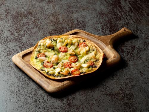 a pizza on a cutting board on a table at Kaname Inn Tatemachi in Kanazawa