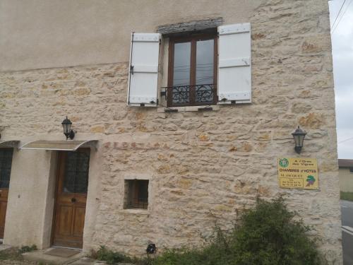 an old stone building with two windows and a door at Meublé A l'Orée des Vignes en Beaujolais in Gleizé