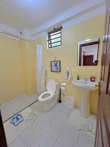 a bathroom with a toilet and a sink at Luxurious Homely Apt 6 in Kisumu