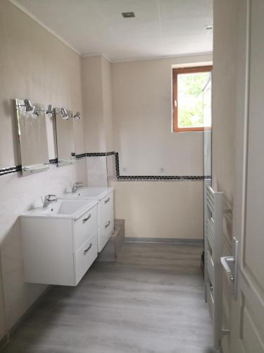 a white bathroom with a sink and a mirror at Meublé A l'Orée des Vignes en Beaujolais in Gleizé
