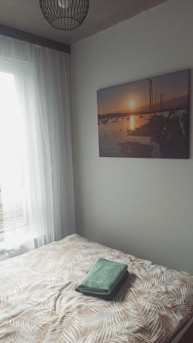 a bedroom with a bed with a green pillow on it at Nyskie Ustronie in Nysa