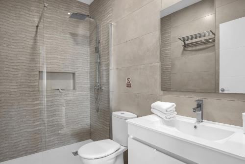 a bathroom with a shower and a toilet and a sink at Casa Sol de Conil in Conil de la Frontera