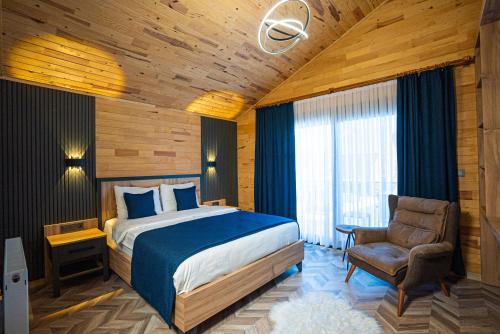 una camera d'albergo con letto e sedia di Abant Sedir Park Butik Otel a Bolu