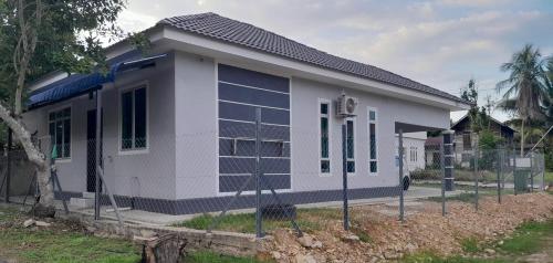 a small white building with a lot of windows at Alya Homestay 295 Sik in Sik