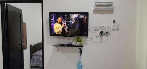 a flat screen tv on a wall in a room at Alya Homestay 295 Sik in Sik