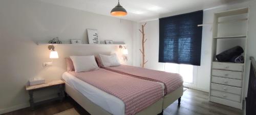 sypialnia z łóżkiem, komodą i oknem w obiekcie Casita 2 w mieście Benajarafe