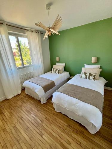 - 2 lits dans une chambre dotée d'un mur vert dans l'établissement La Maison du Quai - face à la sèvre niortaise, à Niort