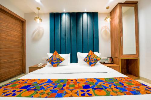 a bedroom with a large bed with a colorful blanket at FabHotel Rolt in Ludhiana