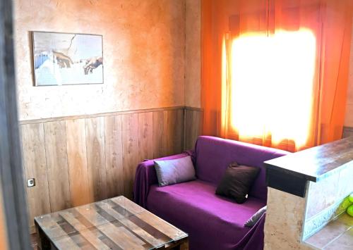 a purple couch in a room with a table at Casa Vaélico in Arenas de San Pedro